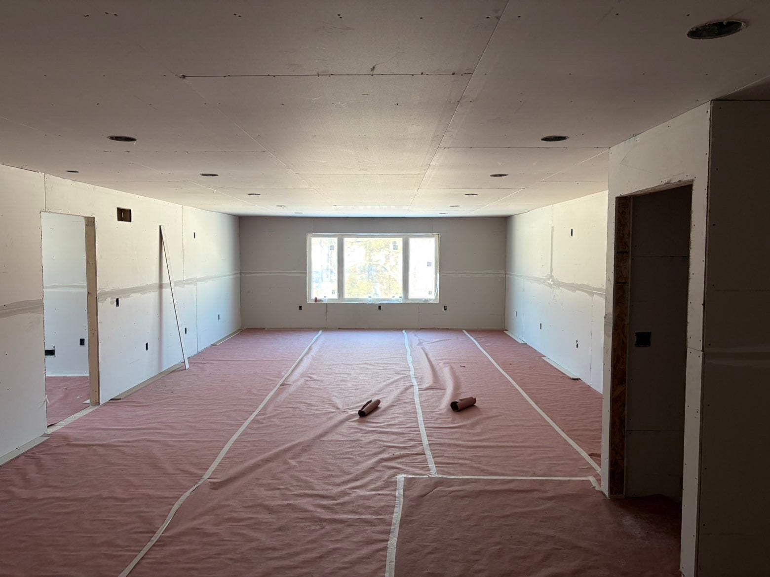 A drywall contractor reviewing a written estimate with a homeowner inside a Madison-area home undergoing renovation